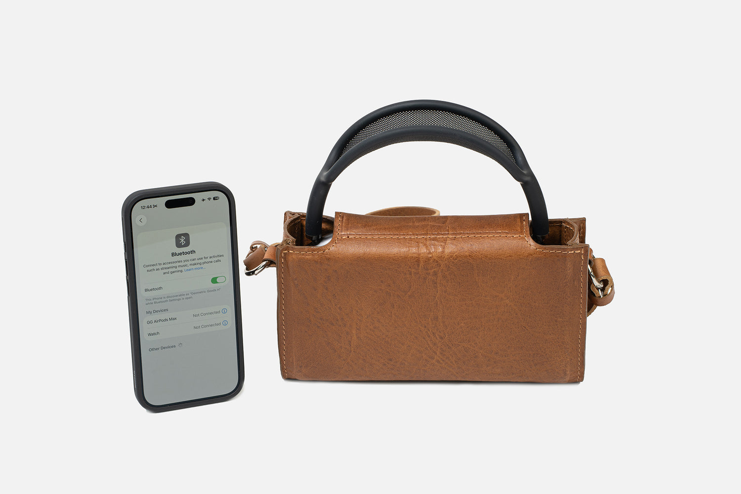 AirPods Max Leather Case Minimalist 3.0 in BROWN with shoulder strap — iPhone screen shows Low Power Mode activation; full-grain Italian leather travel case