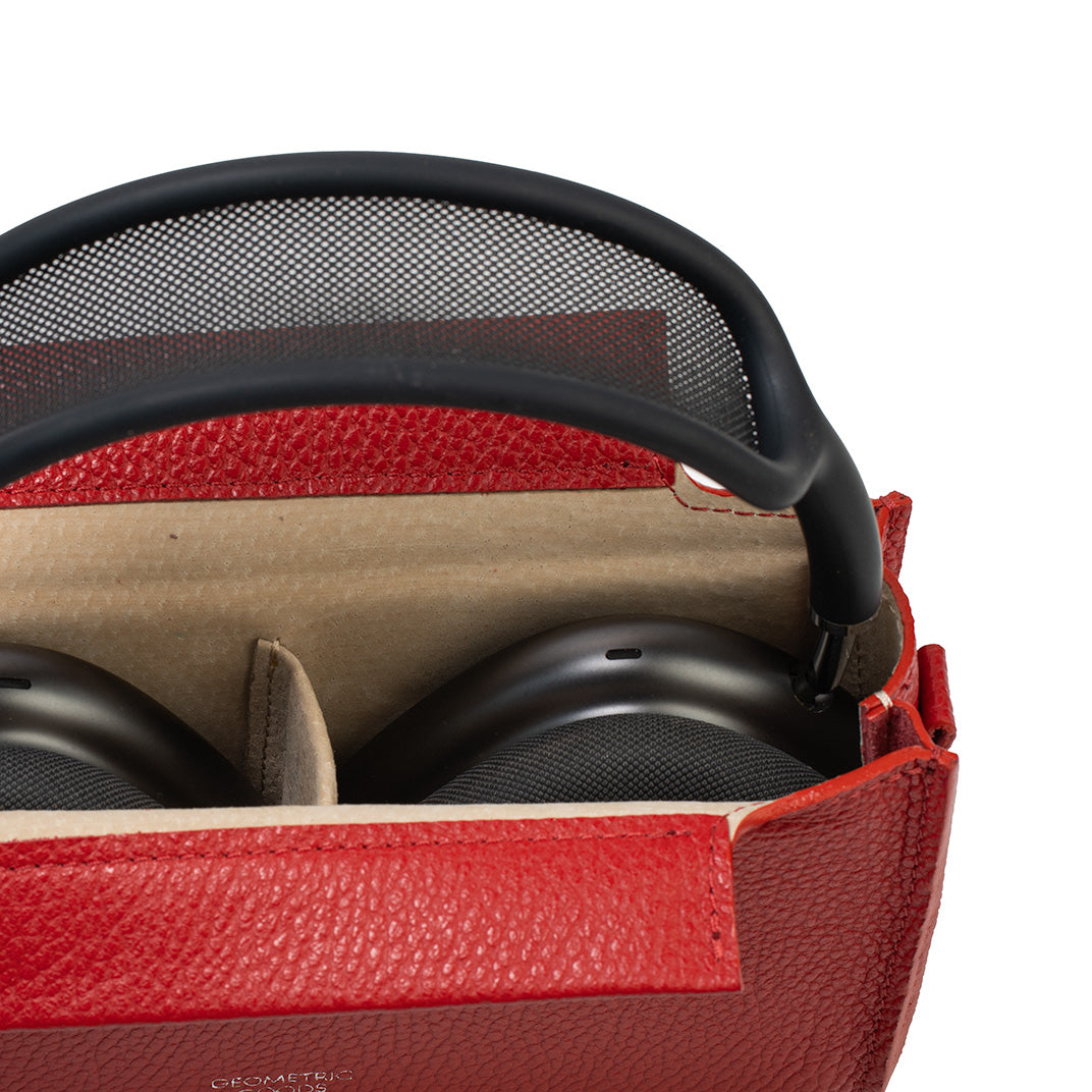 Close-up of red genuine Italian leather AirPods Max case showing soft lining and center divider with headphones inside.
