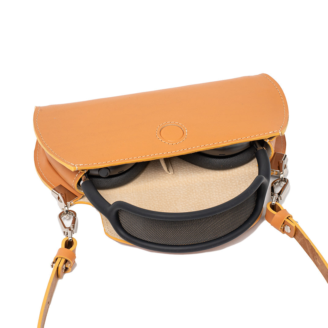 Open orange leather crossbody case for AirPods Max by Geometric Goods, showing headphones neatly stored inside beige fabric-lined i