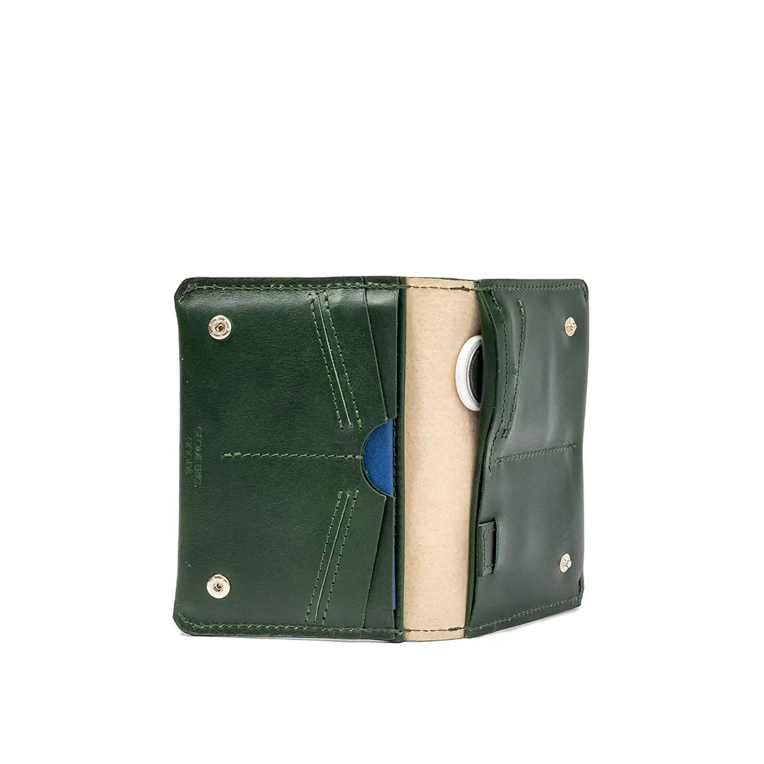 Open green leather passport wallet with stitched interior pockets and a beige center lining.