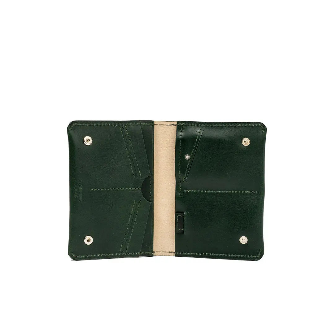 Open green leather passport wallet showing stitched interior pockets and a beige center lining.