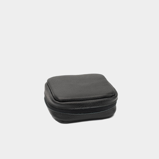 Closed black flat-grain leather Mac Mini case showing the structured shape and zip-around edge
