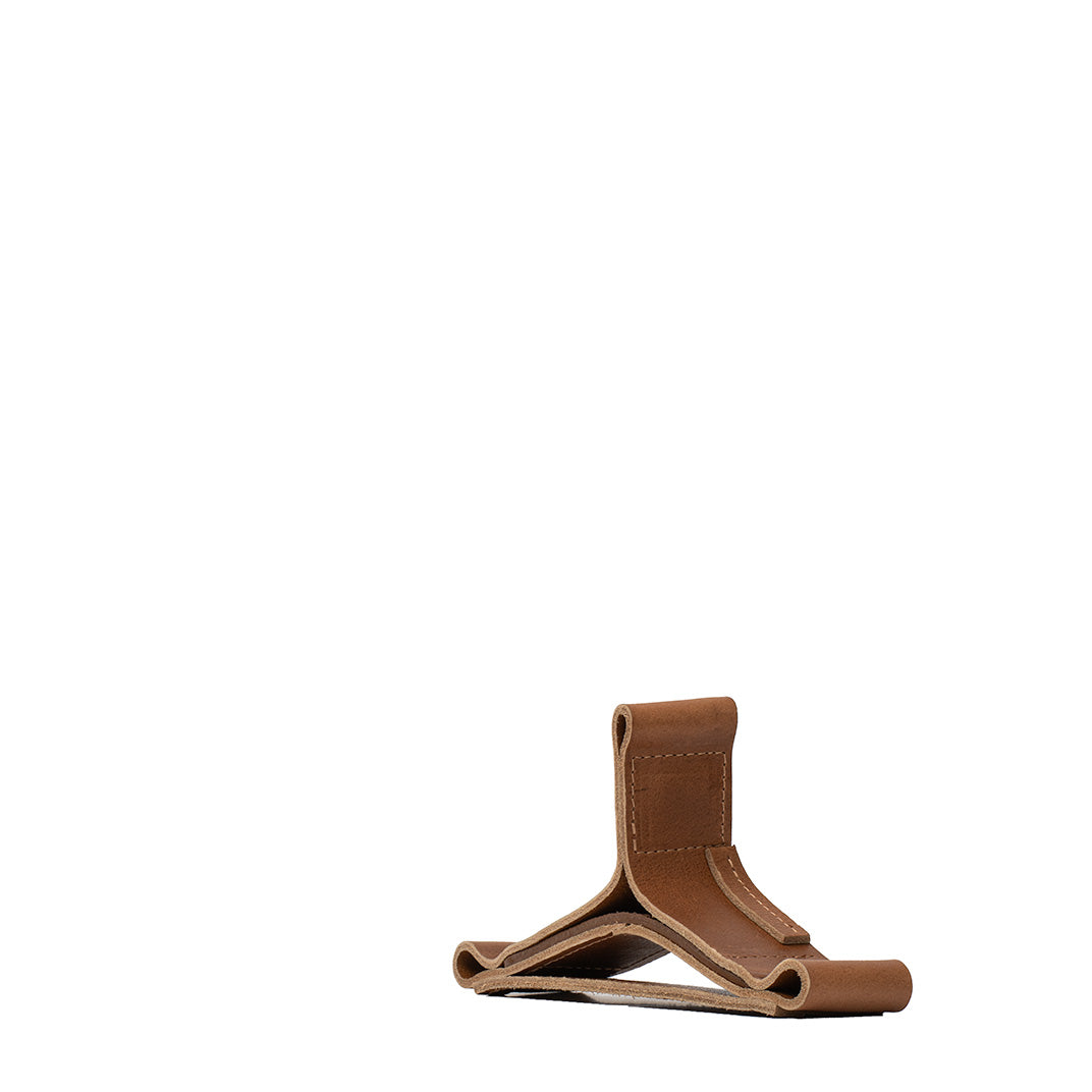 Brown Italian leather AirPods Max stand – side view showing sculpted cradle for sleep mode and desktop storage