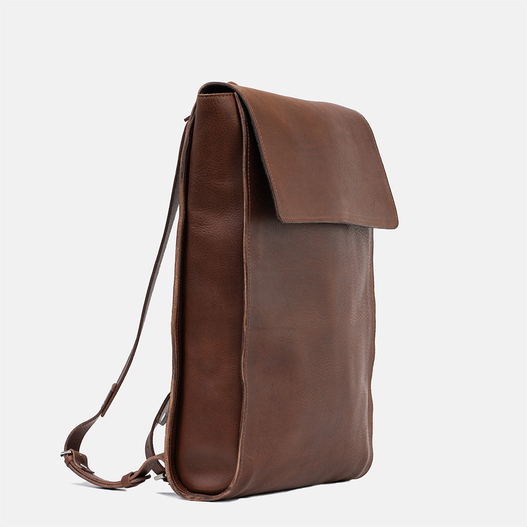 Leather backpack in mahogany, side profile highlighting minimalist design, perfect for designers and men's use
