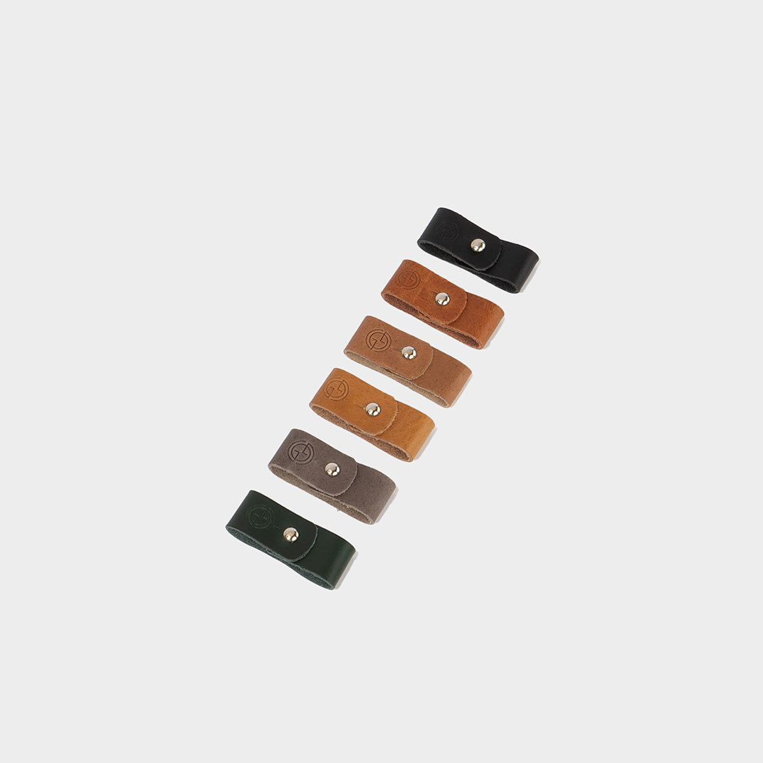 Variety of leather cable holders in multiple colors with metal snap closures