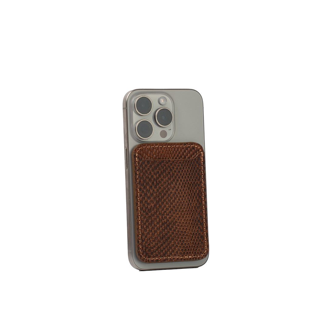 Brown embossed snake print leather MagSafe wallet for iPhone, vegetable-tanned leather, handcrafted, shown attached to iPhone 16 Pro