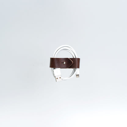 the photo of vintage-style cord organizer made from full-grain leather by Geomeric Goods in mahogany color
