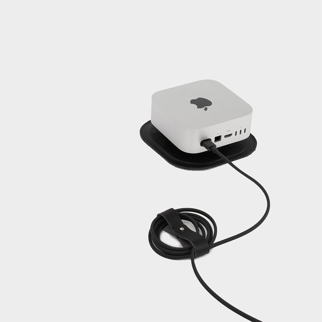 Leather cable holder keeping power cord tidy behind Mac mini computer