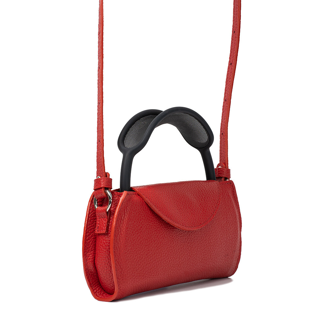 Side angle of Gometric Goods’ Ruby Red Leather AirPods Max Shoulder Case, showing the headphone band and adjustable strap.