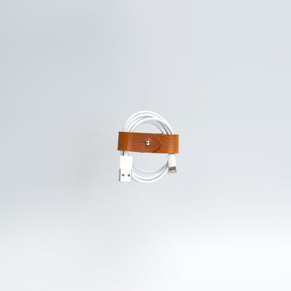 the photo of vintage-style cord organizer made from full-grain leather by Geomeric Goods in tan color
