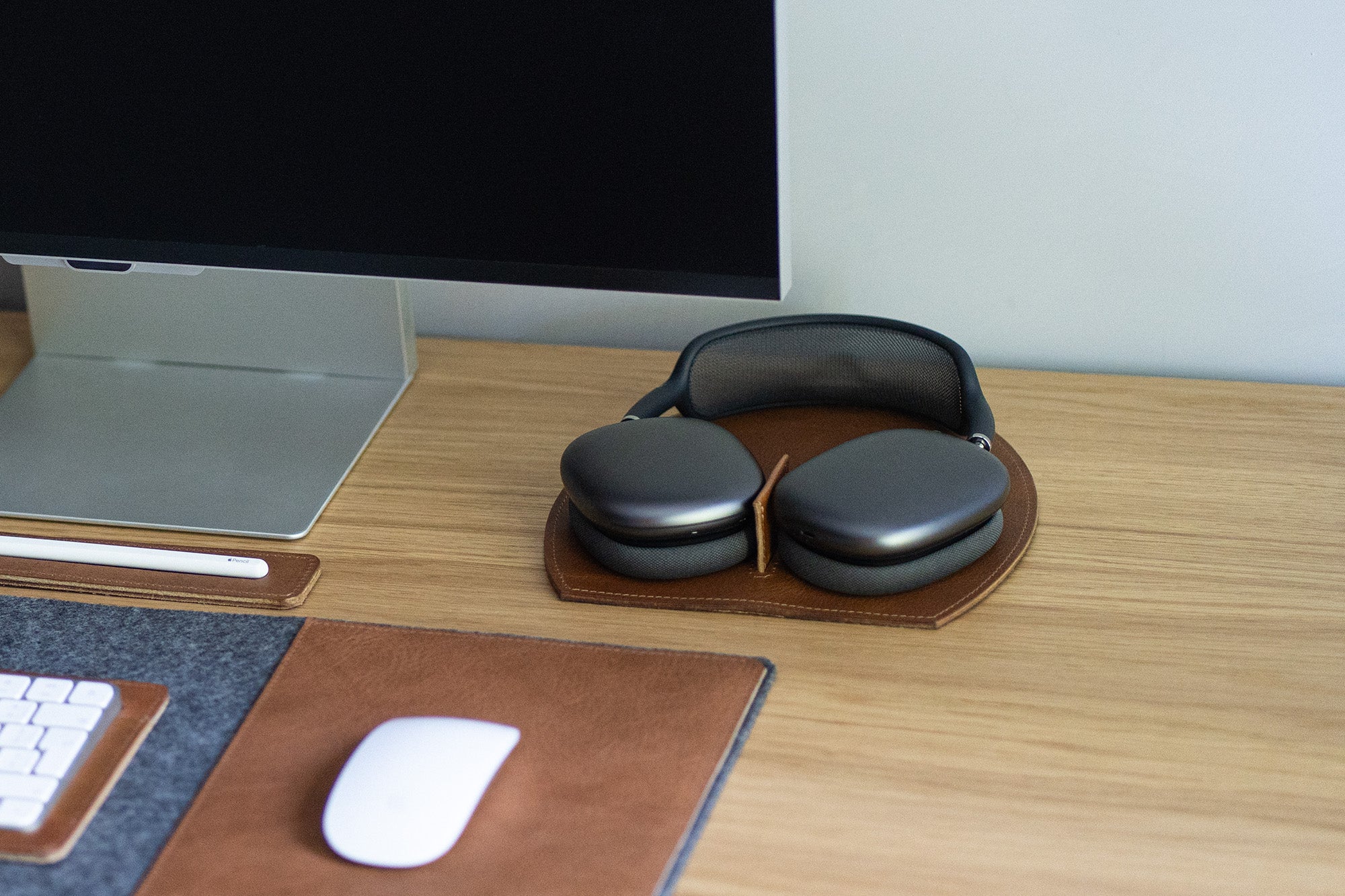 AirPods Max on a brown leather rest station; magnets trigger low-power mode on dock