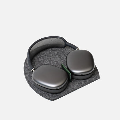 AirPods Max resting on a grey Merino felt Rest Station 2.0 with a green leather insert
