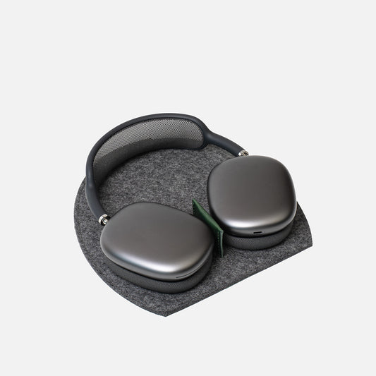AirPods Max resting on a grey Merino felt Rest Station 2.0 with a green leather insert