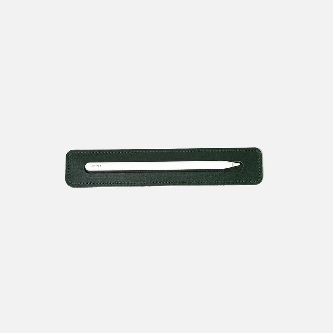 Forest green leather tray holding a white Apple Pencil, viewed from above