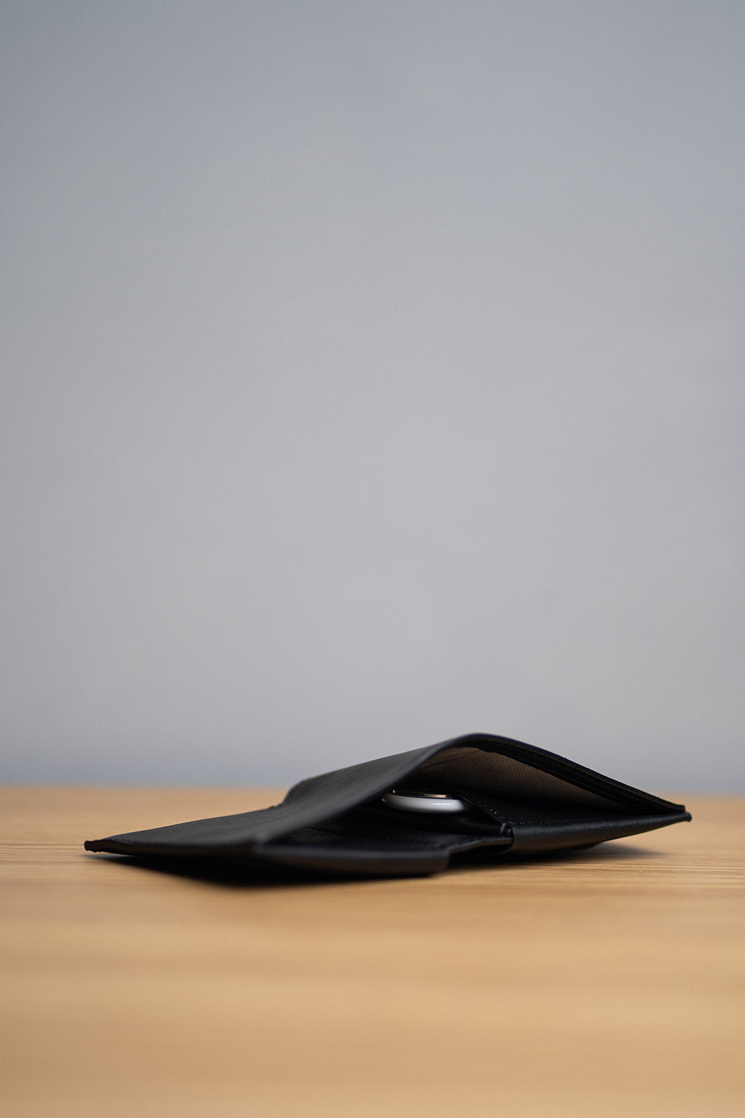 How to attach an AirTag to a wallet: insert AirTag into the leather airtag wallet pocket.