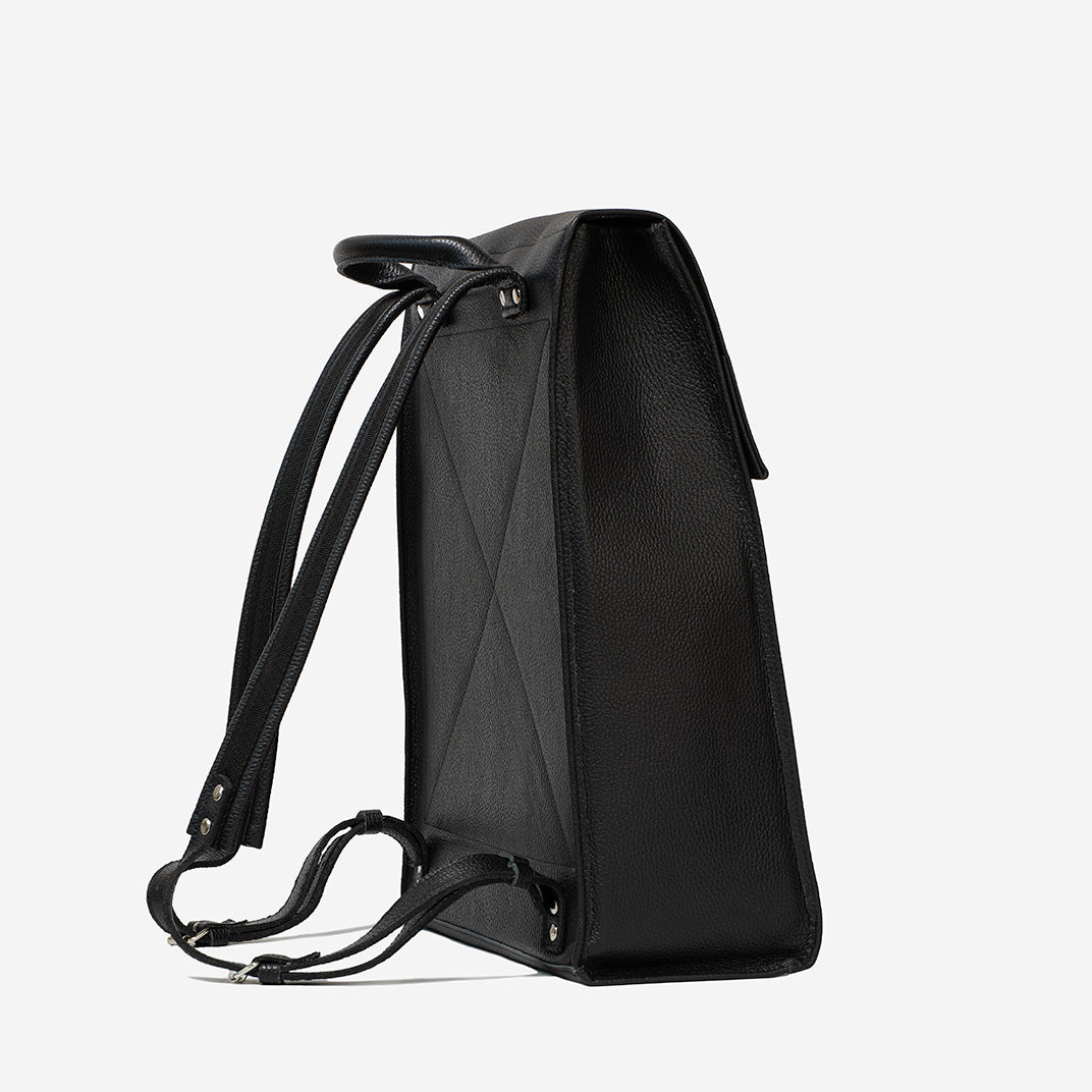 Back angled view of black leather commuter bag with adjustable straps and reinforced stitching