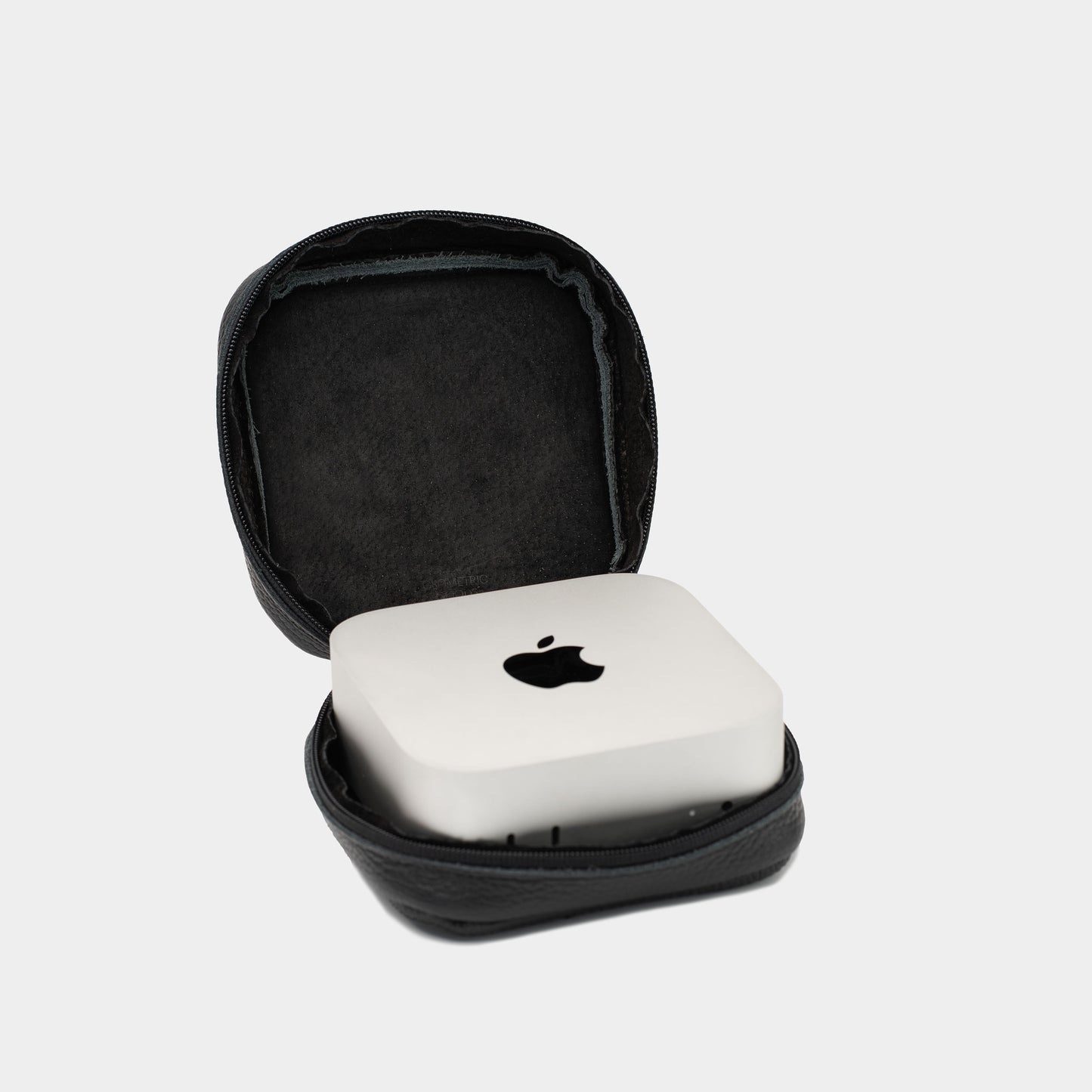 Open black flat-grain leather Mac Mini case with soft interior lining and Apple Mac Mini placed inside
