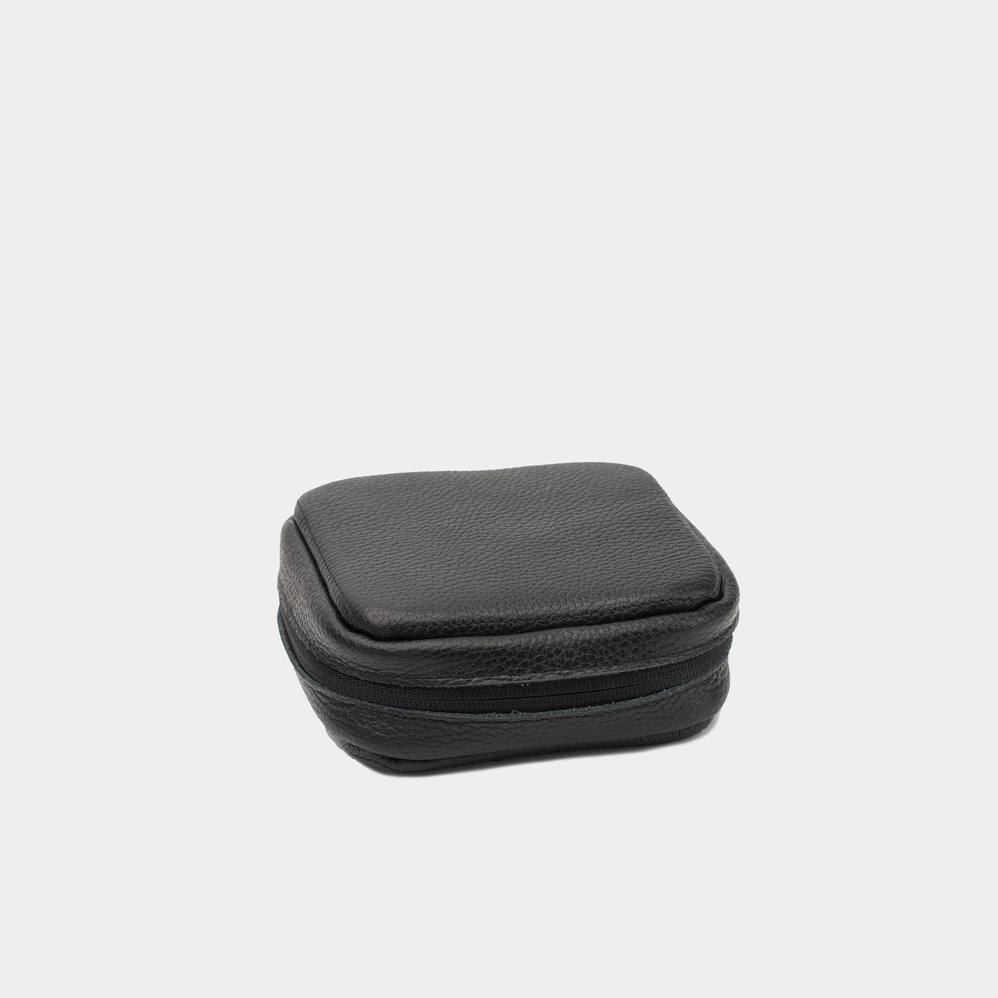 Closed black flat-grain leather Mac Mini case showing the structured shape and zip-around edge