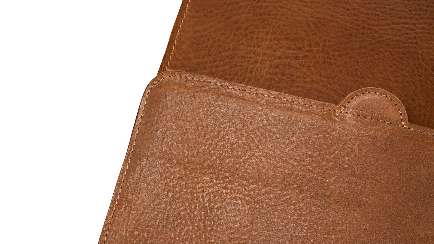 Close-up detail of brown leather backpack, showcasing the high-quality craftsmanship and texture