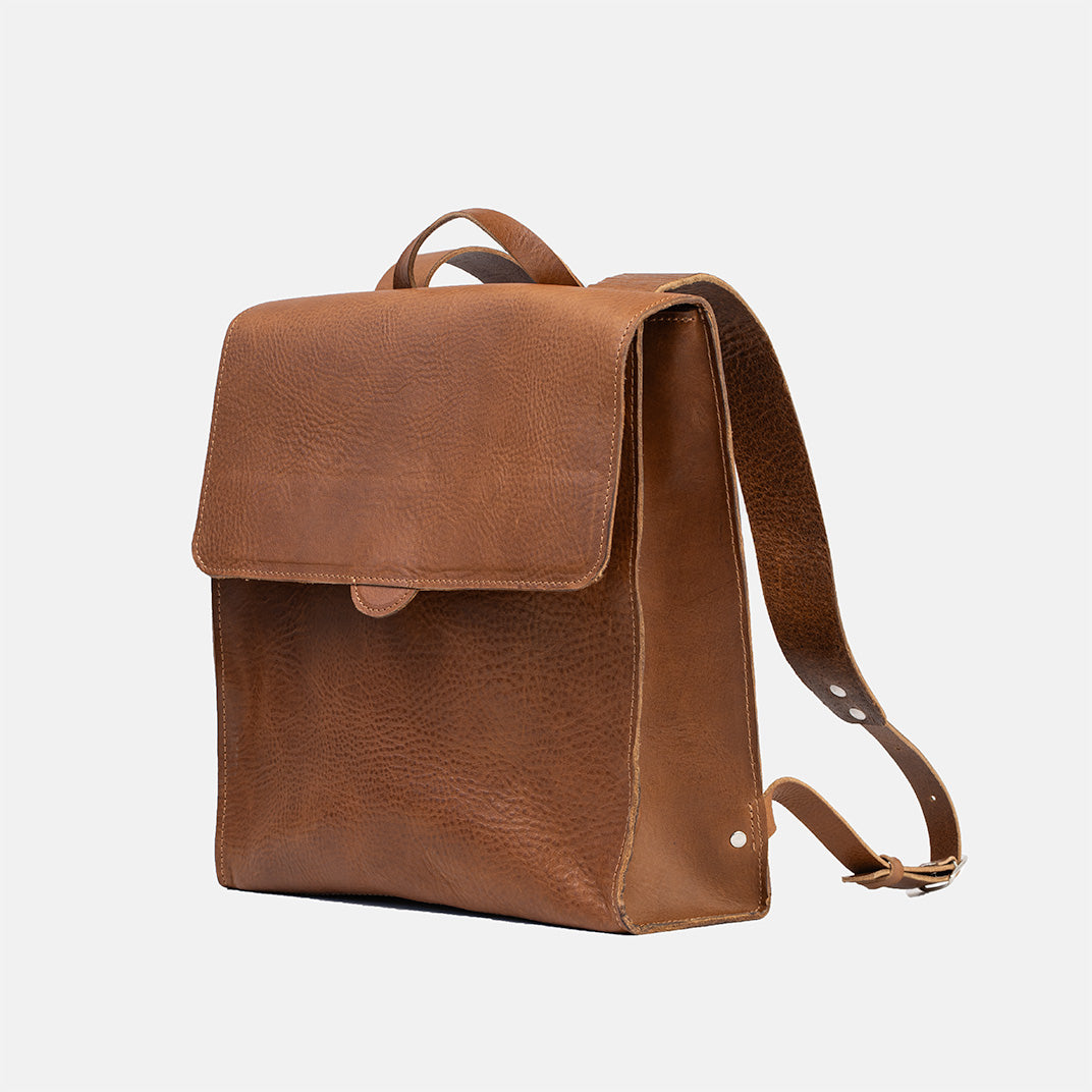 Brown leather backpack for women, featuring a side profile view with adjustable straps and stylish design