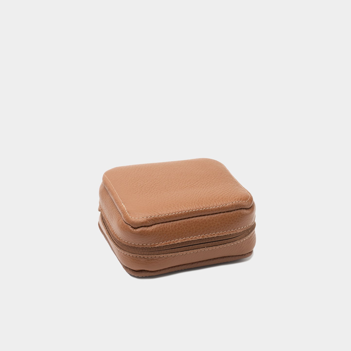 Closed brown flat-grain leather Mac Mini case showing the textured exterior and compact zip-around design