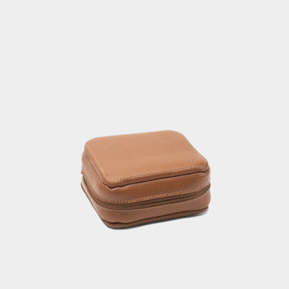 Closed brown flat-grain leather Mac Mini case showing the textured exterior and compact zip-around design