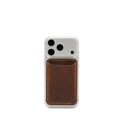 Brown embossed snake print leather MagSafe wallet attached to a silver iPhone, shown from the rear