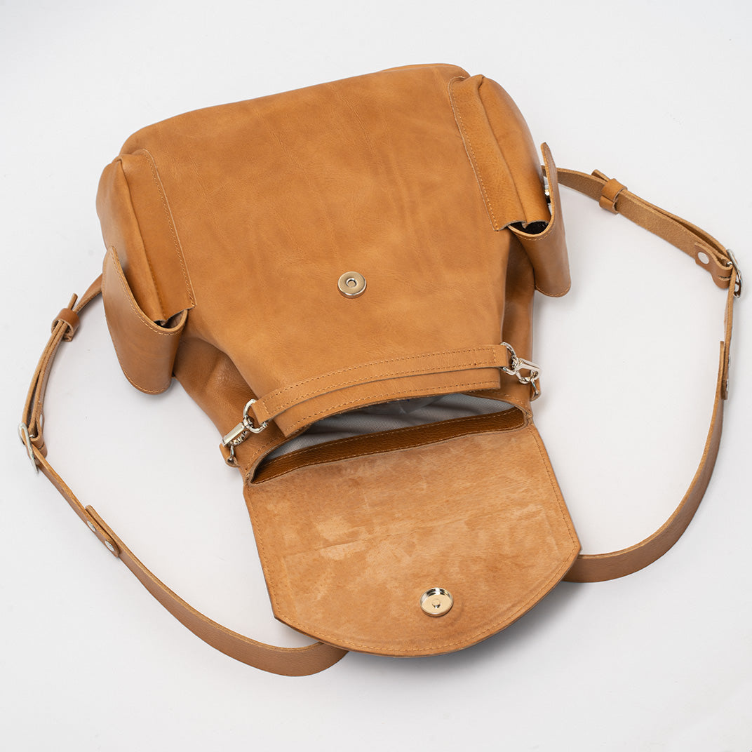 Compact camel leather knapsack with adjustable straps and a durable flap closure, ideal for women who need a designer backpack for essentials.