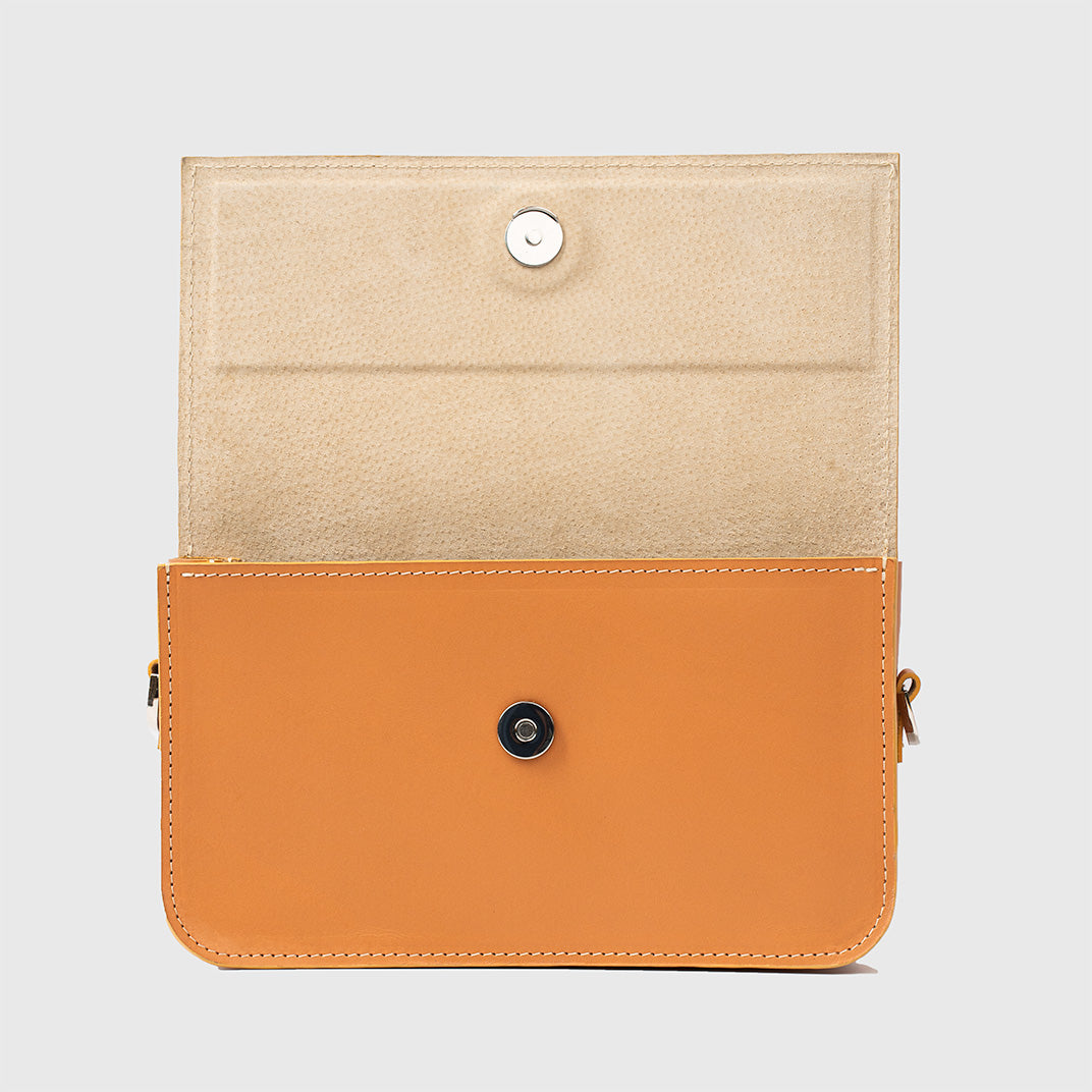 Close-up of light-orange leather purse showing structured design and stitching.