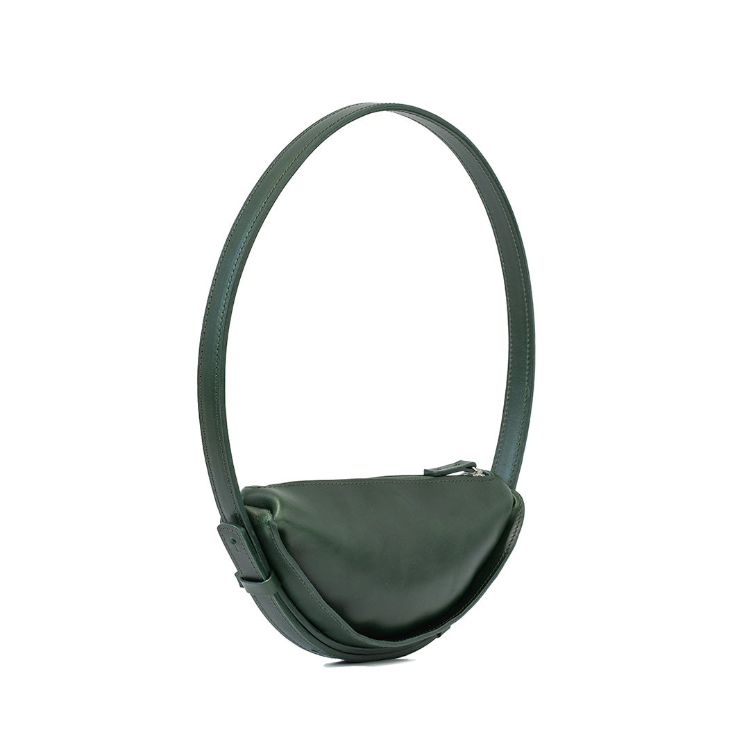 Shoulder bag styled as a half moon bag in forest green leather, highlighting the crescent bag's chic profile and subtle elegance