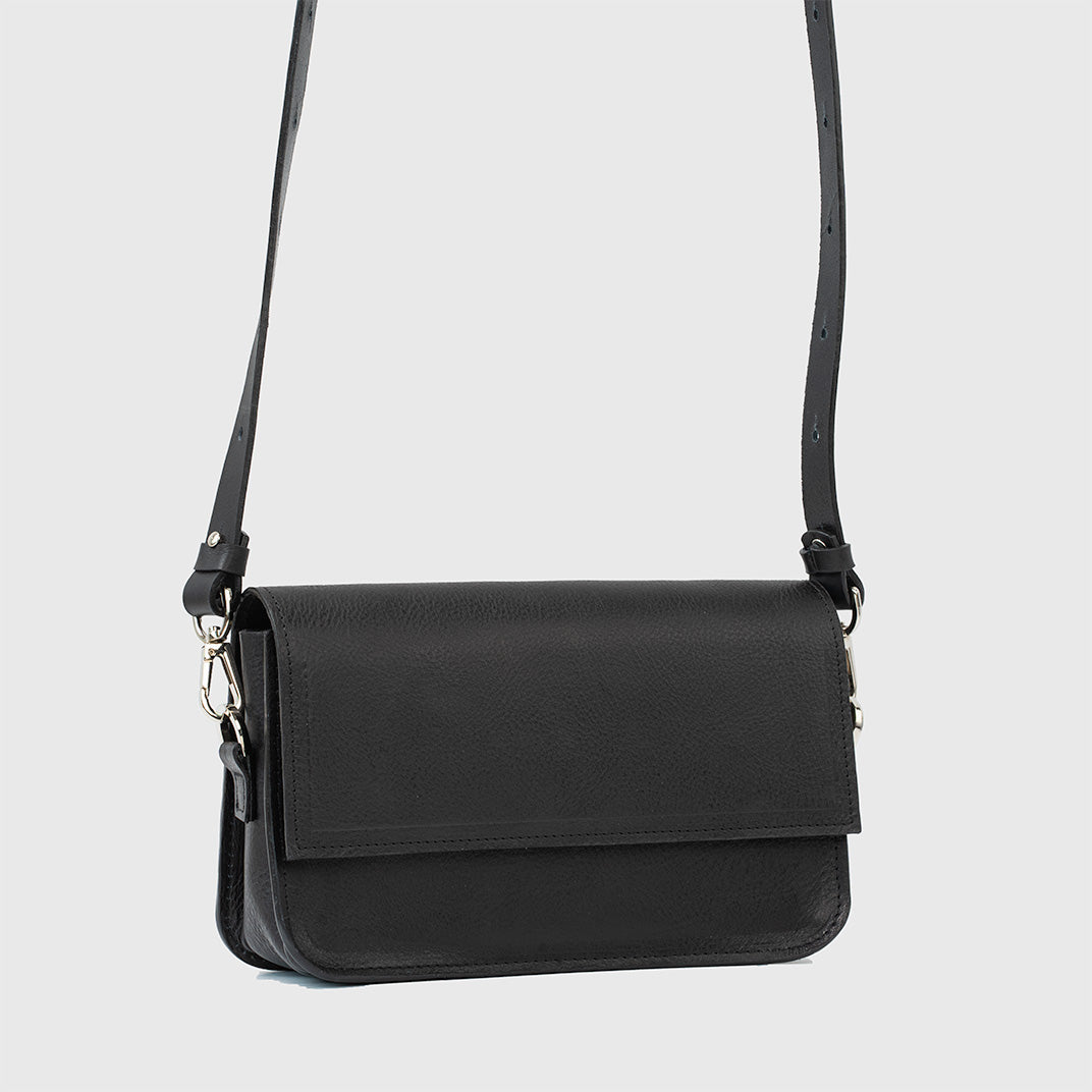 Classic black shoulder bag with minimalist design, displayed with strap extended