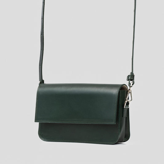 Classic dark green shoulder bag with minimalist design, displayed with strap extended