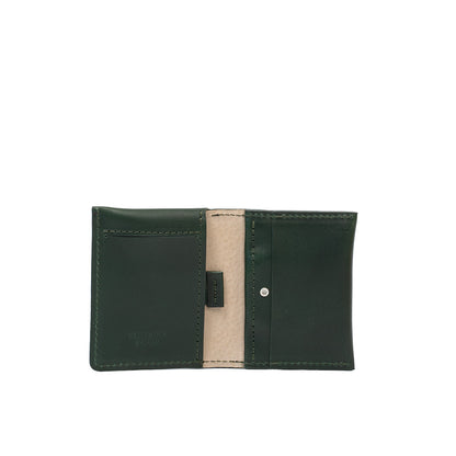 Open view of green leather AirTag card wallet showing card slots and secure pocket.