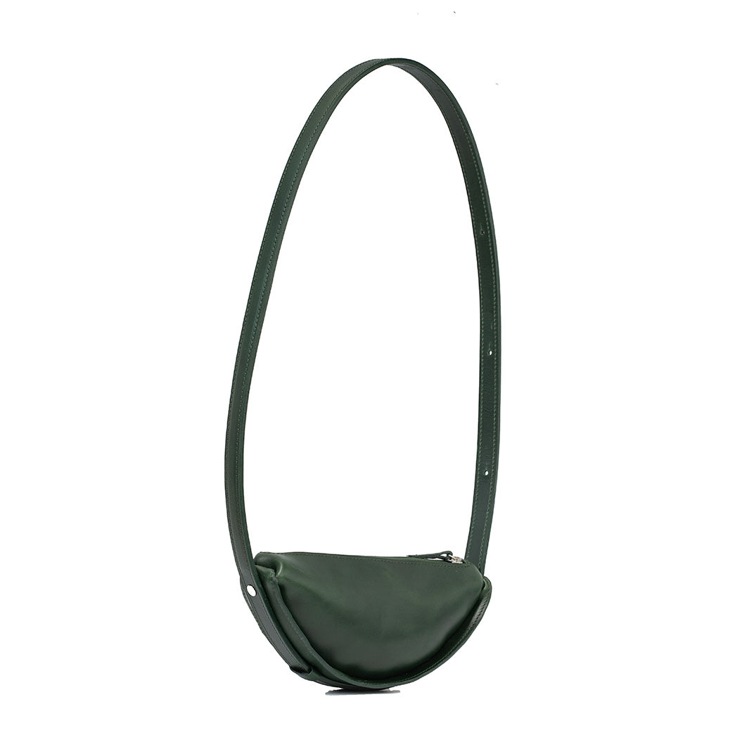 Shoulder bag fashioned as a half moon bag in rich green leather, displaying the crescent bag's elegant long strap and minimalist style