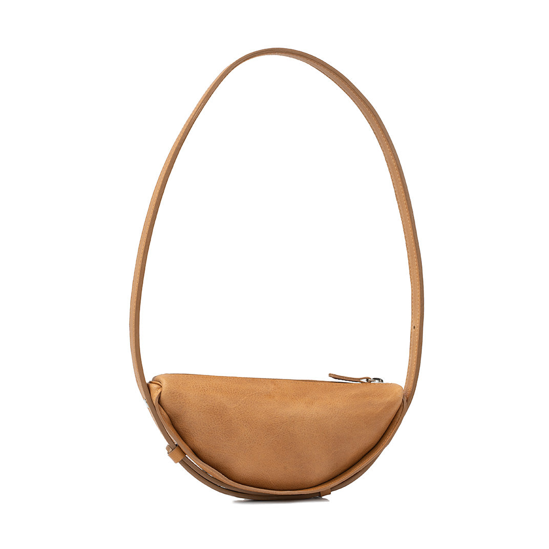 Shoulder bag portrayed as a half moon bag in sumptuous camel leather, emphasizing the crescent bag's sleek profile and spacious design.