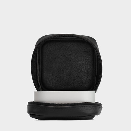 Side angle view of the Mac Mini inside the black leather case, emphasizing secure storage and reinforced walls