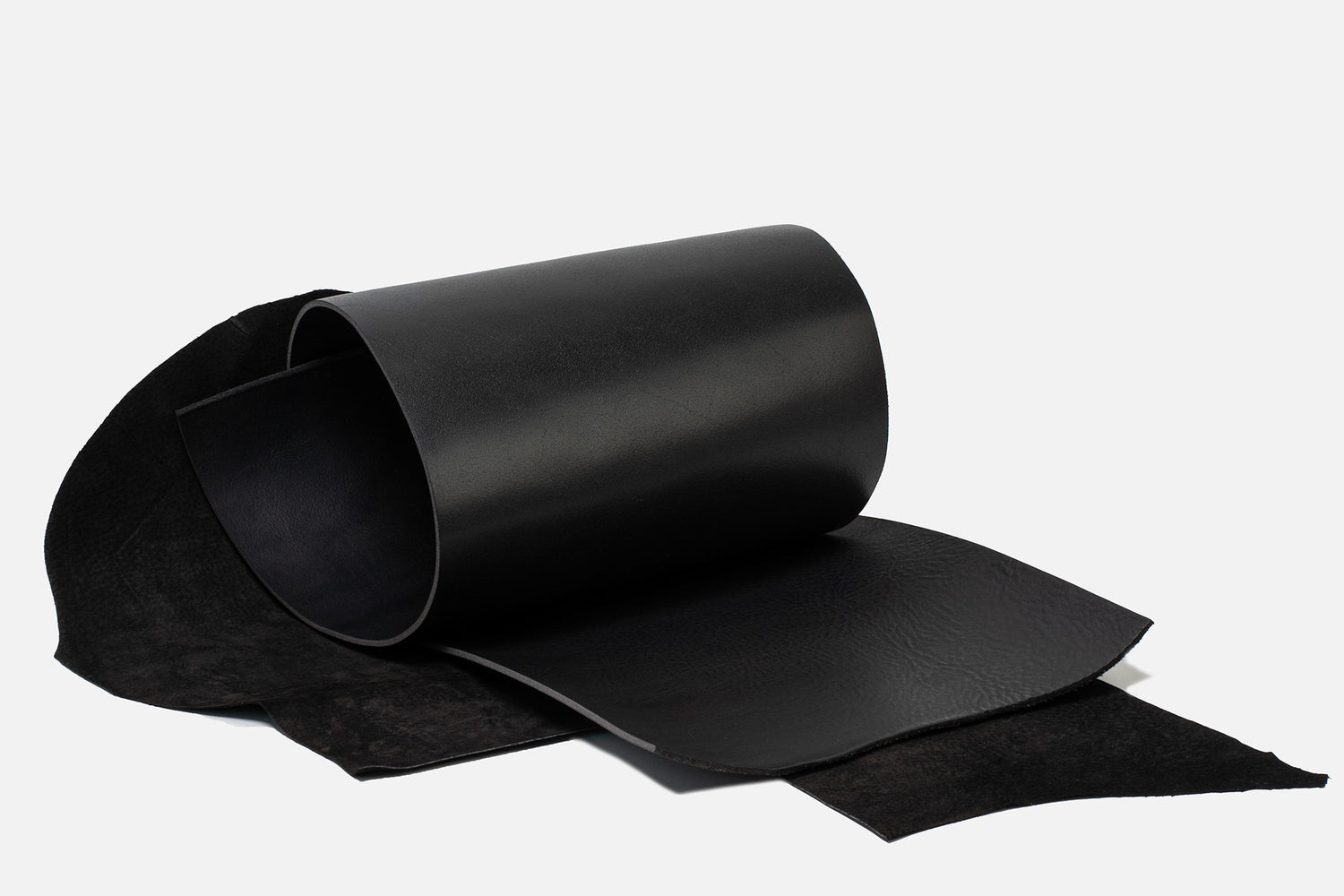 Rolled sheets of Italian vegetable-tanned cowhide and soft suede in black — premium materials for the Classic 5.0 iPhone 17 leather folio case