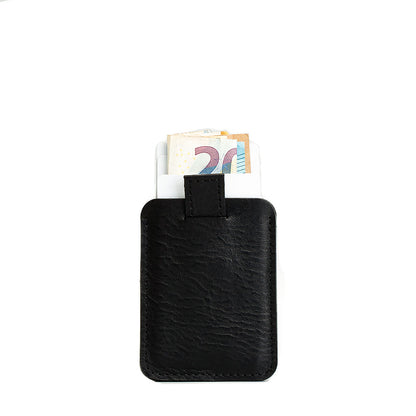 Designer black full-grain leather cardholder with a practical pull tab, shown holding various currencies, ideal for efficient card and cash storage