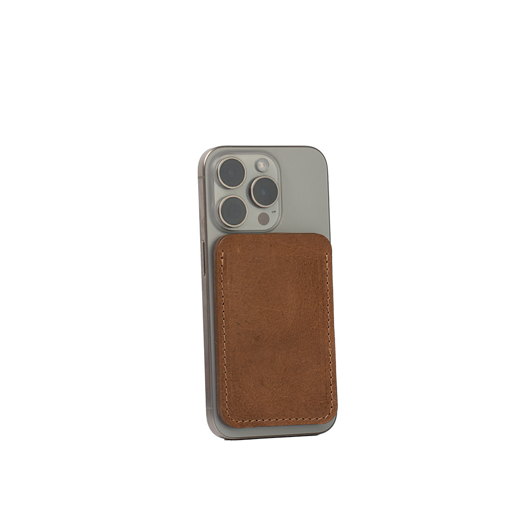 Minimalist brown leather MagSafe wallet for iPhone, handcrafted from Italian vegetable-tanned leather, shown on iPhone