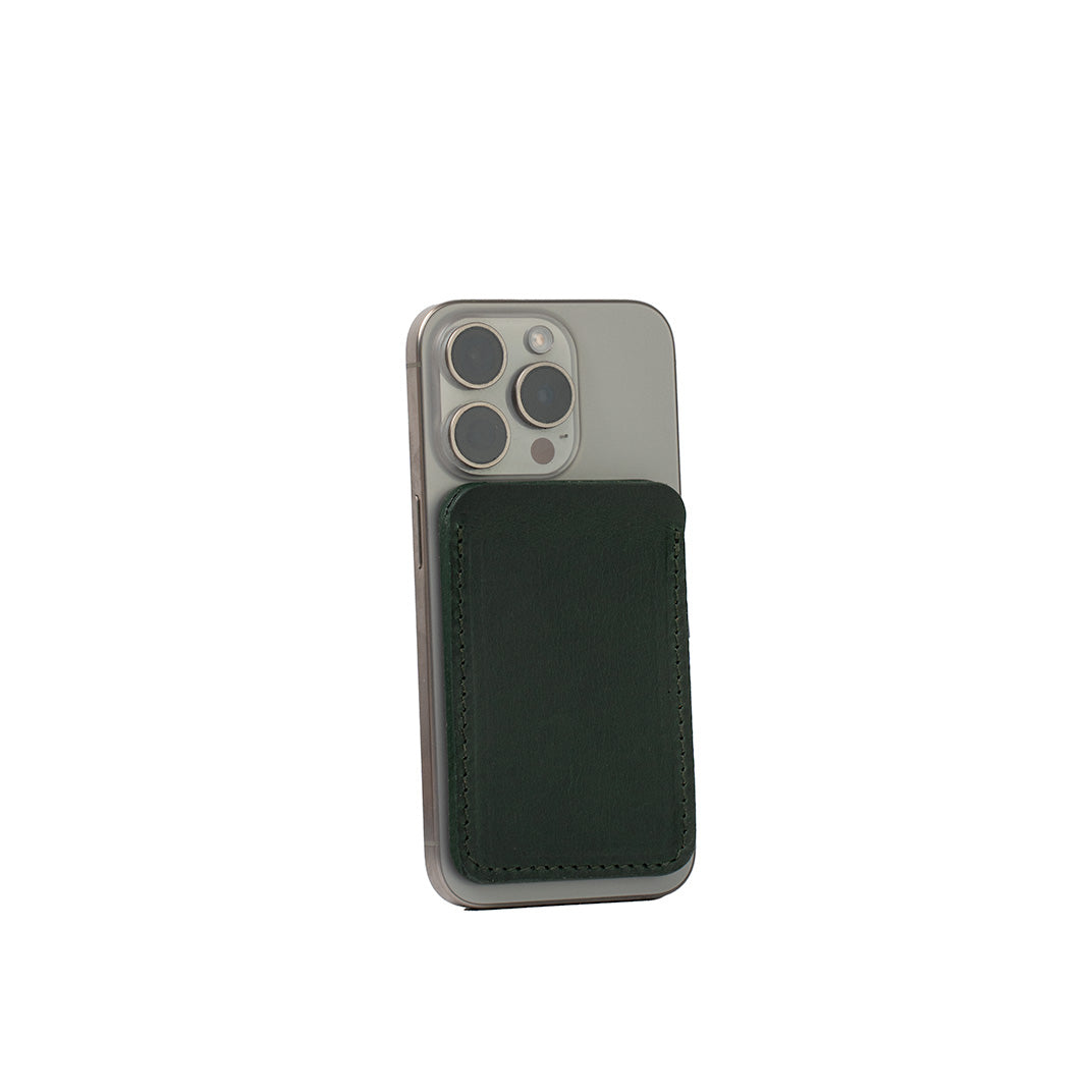 Minimalist forest green leather MagSafe wallet for iPhone, handcrafted from Italian vegetable-tanned leather, shown on iPhone