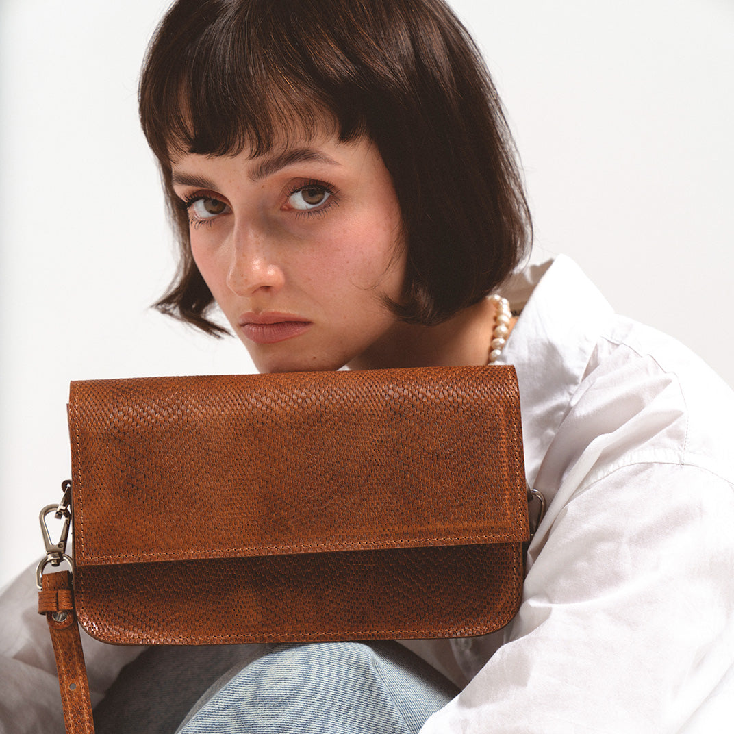 Model showcasing a Leather Shoulder Bag in Brown Snake Print by Geometric Goods, featuring premium Italian leather and an exotic design for a bold, sophisticated look