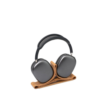 Leather stand for AirPods Max in Velour Sand by Geometric Goods, holding space gray headphones upright with a minimal, sculptural design
