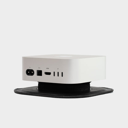 Detailed view of a black leather Mac Mini M4 stand with a sturdy platform, perfect for a modern workspace