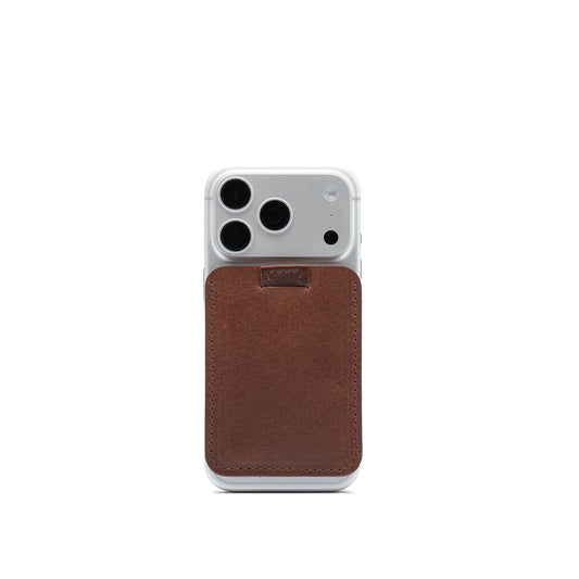 Mahogany leather wallet compatible with MagSafe attached to a silver iPhone, with pull tab at the top