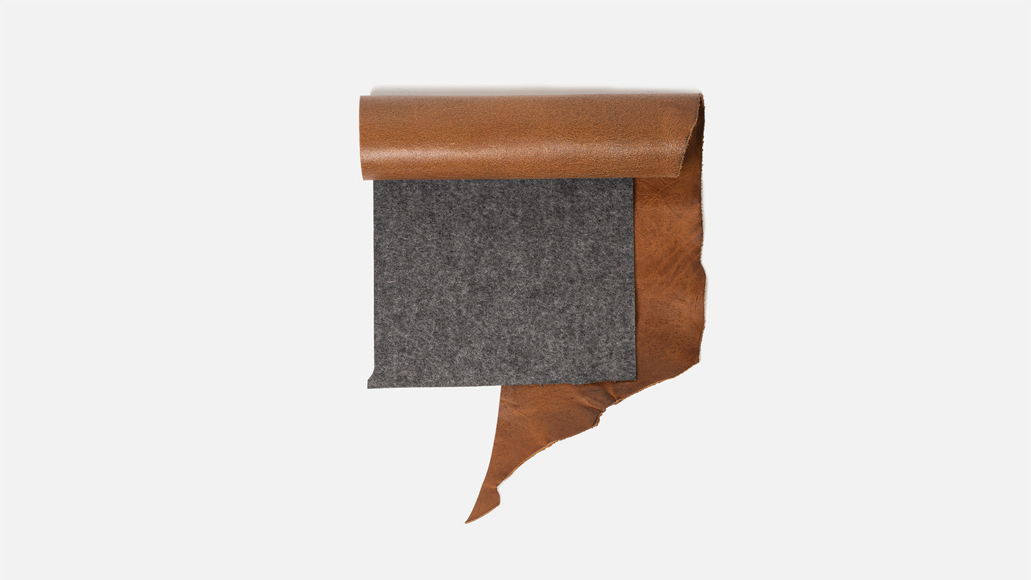 Grey merino wool felt sheet layered over tan vegetable-tanned full-grain Italian leather on a white background.
