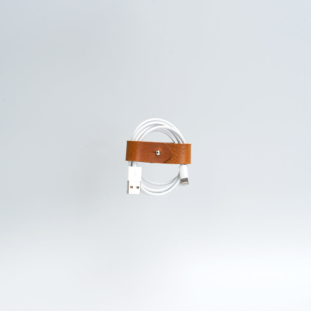 the photo of vintage-style cord organizer made from full-grain leather by Geomeric Goods in tan color