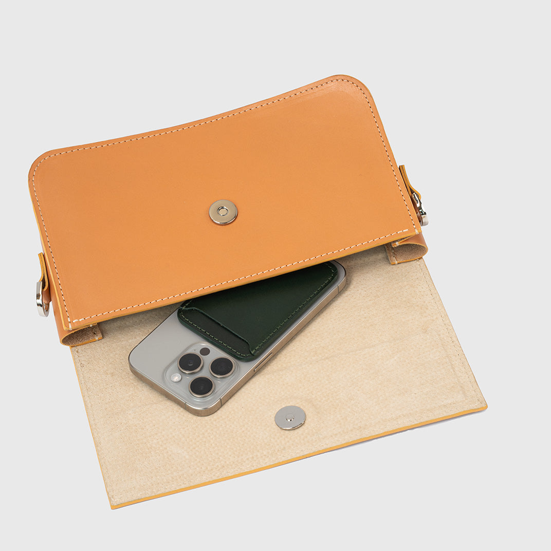 Interior view of light-orange leather shoulder bag with organized compartments.